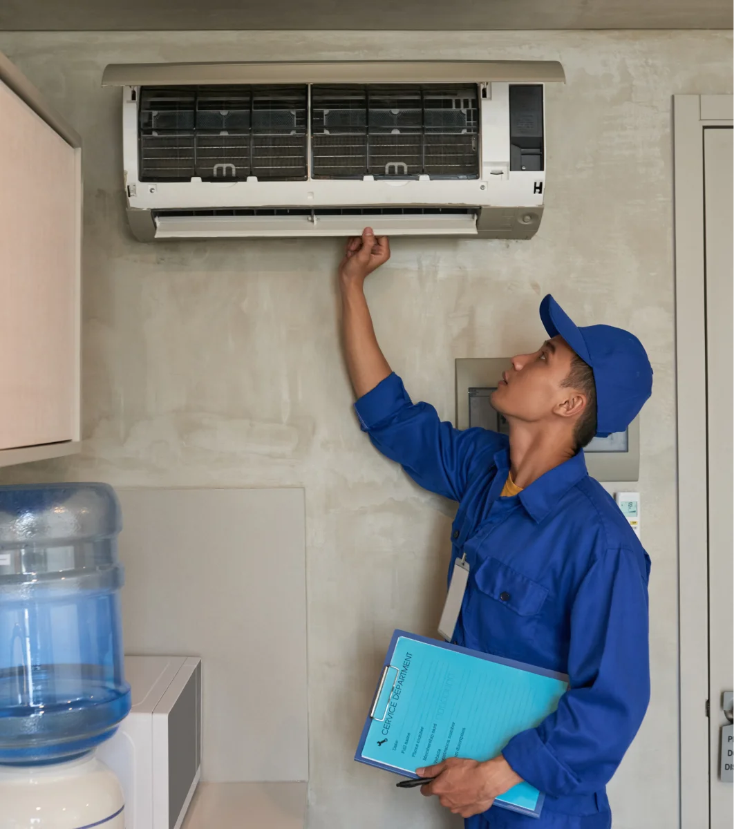 A man inspecting a ductless system in a kitchen.